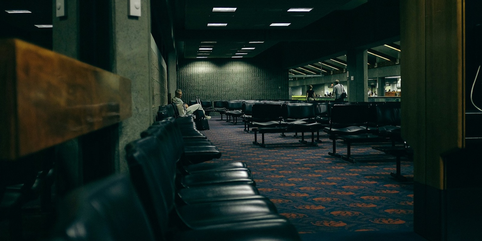 Rows of empty seats in a dim institutional waiting area