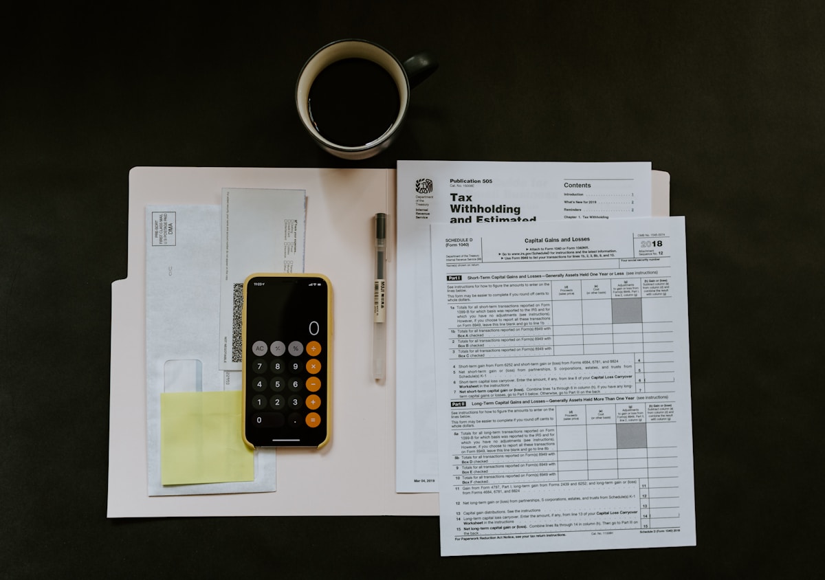 A person at a kitchen table compares a paper medical bill against a written cost estimate, with a health insurance card beside them