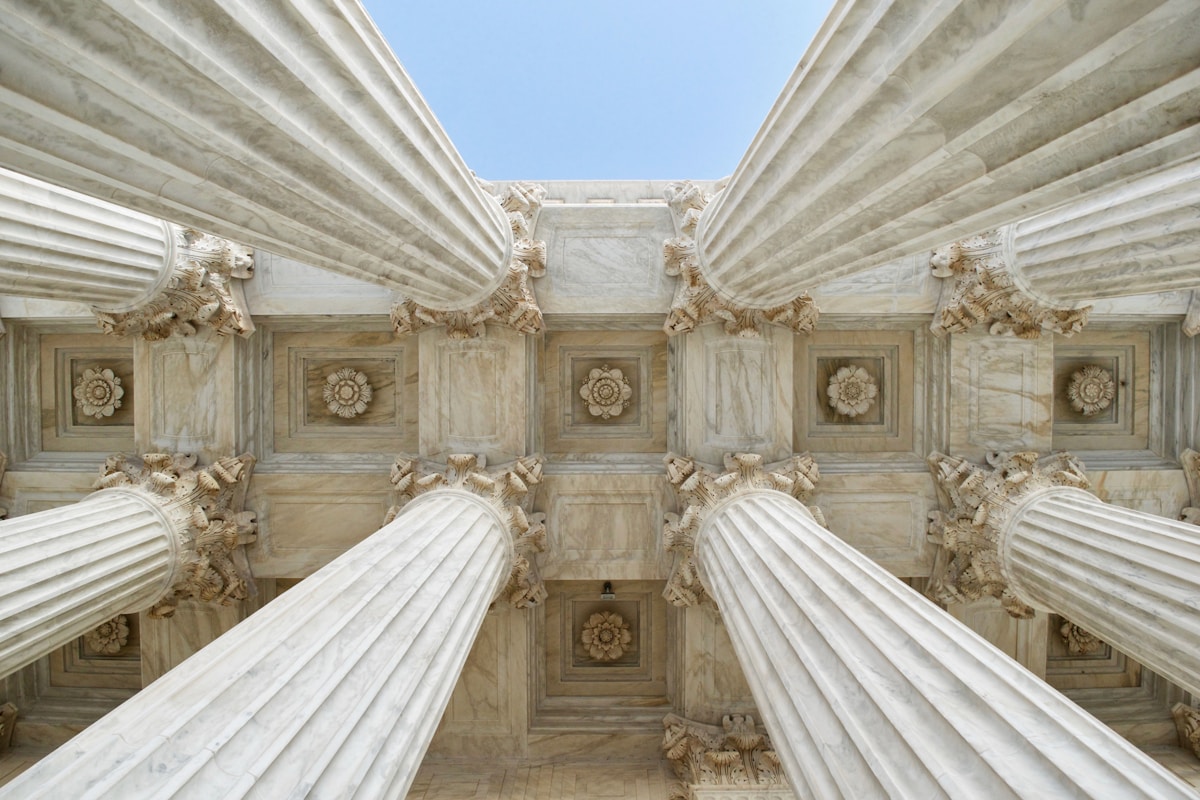 A state insurance regulator's office building seen from below against an overcast sky